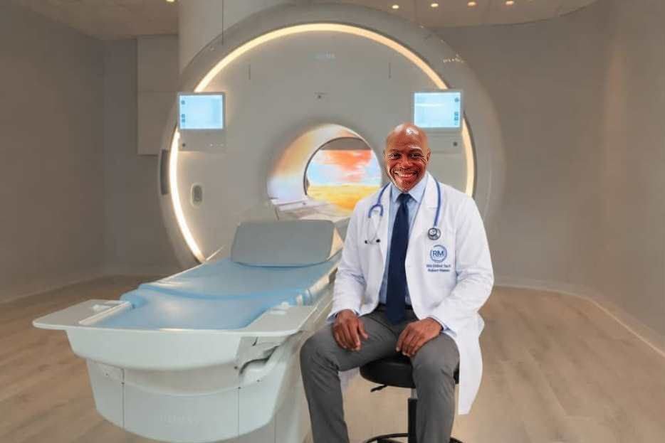 Robert Mateo of RM OrthoMed Technologies seated beside a commissioned wide-bore MRI scanner in a finished imaging suite.